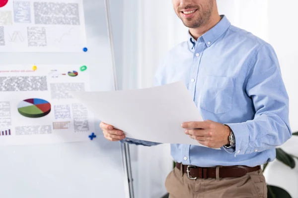 Ausgeschnittene Ansicht eines fröhlichen Geschäftsmannes mit leerem Papier im Amt — Stockfoto