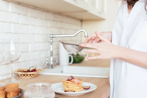 Cropped view of woman using sieve while preparing breakfast in kitchen — Stock Photo