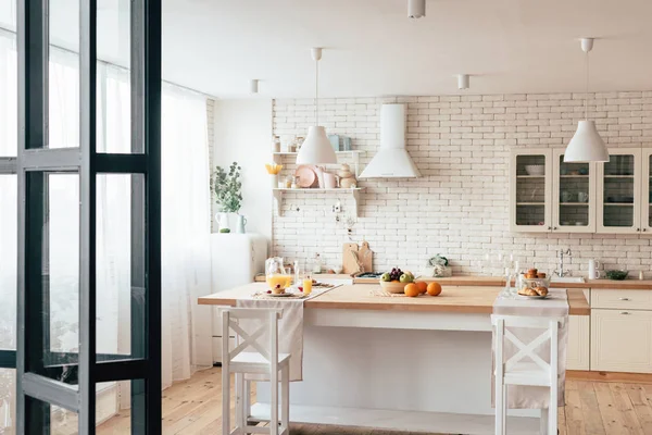 Acogedora cocina moderna con mesa servida y sillas - foto de stock