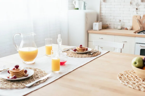 Served table with pancakes, syrup and orange juice — Stock Photo