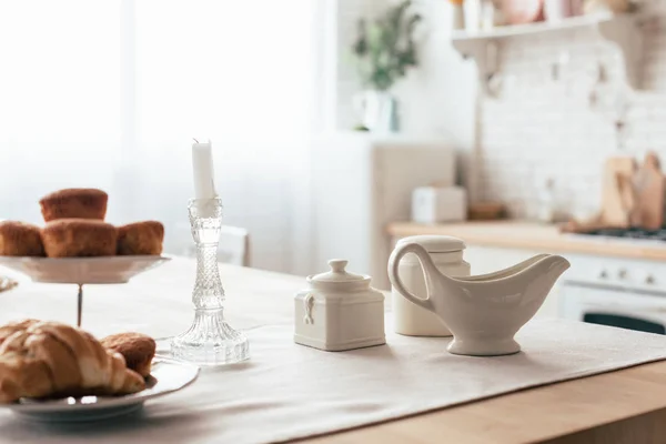 Bolos e croissant na mesa servida na cozinha — Fotografia de Stock