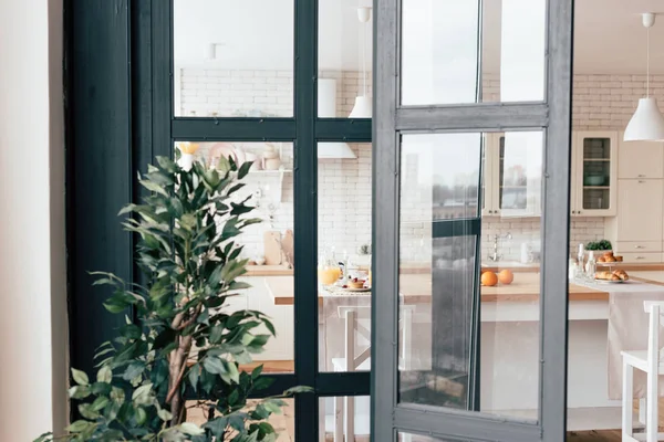 Open kitchen windows, served table with food and green plant — Stock Photo