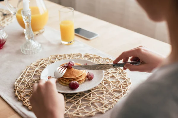 Partial view of woman eating pancakes in kitchen — Stock Photo