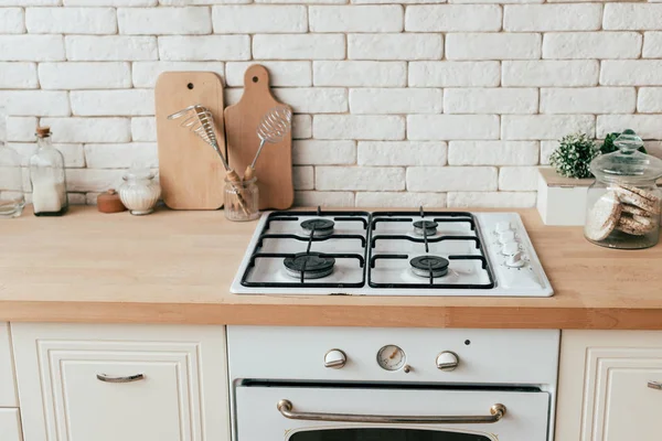 Horno, gofres de arroz, utensilios de cocina y plantas en la cocina - foto de stock