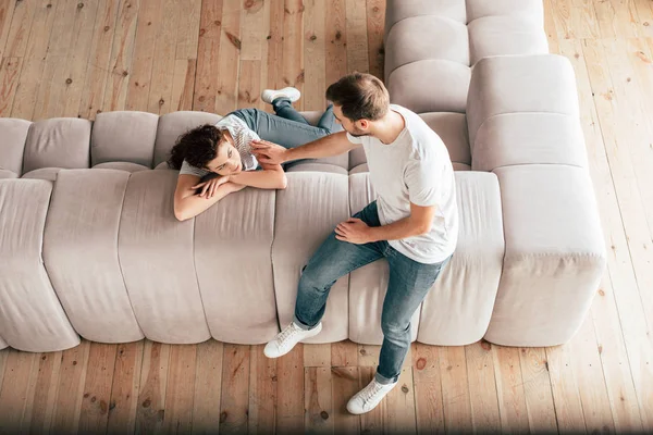 Blick von oben auf ein Paar, das auf dem Sofa sitzt und einander ansieht — Stockfoto