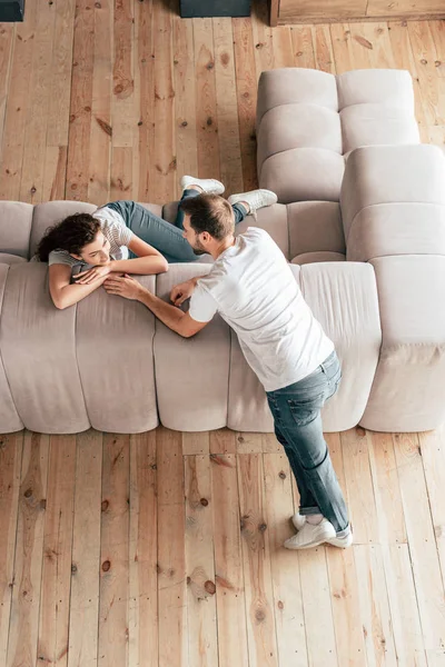 Overhead view of happy couple looking at each other in living room — Stock Photo