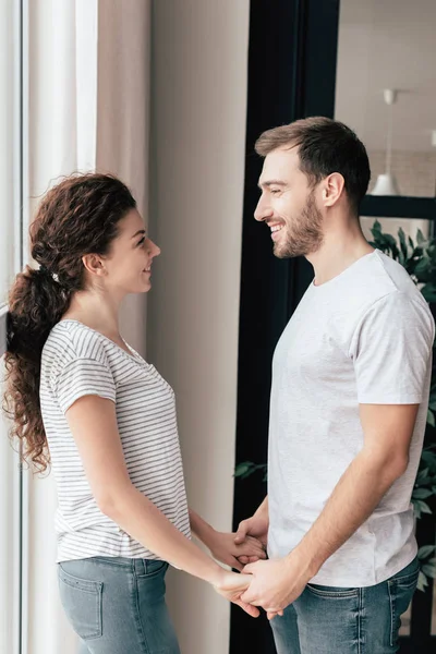 Lächelndes Paar, Händchen haltend und einander anschauend — Stockfoto