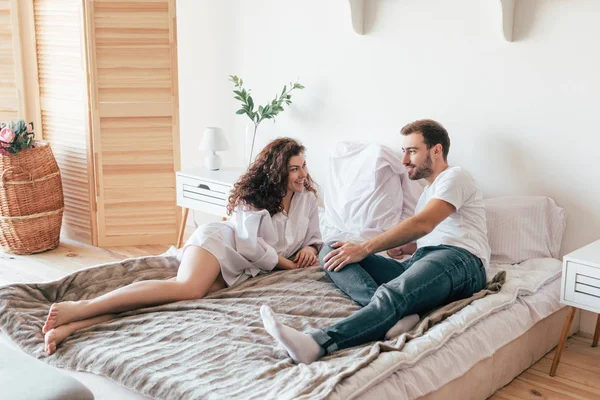 Couple souriant couché sur le lit et se regardant — Photo de stock