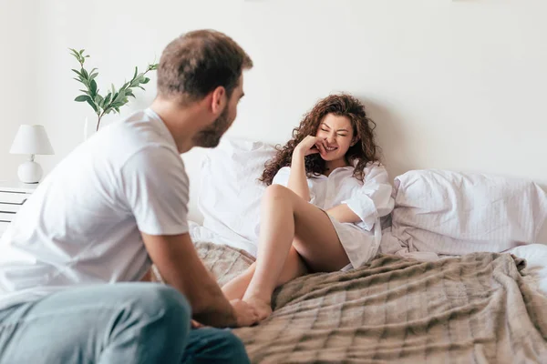 Liebendes Paar schaut einander auf dem Bett an — Stockfoto