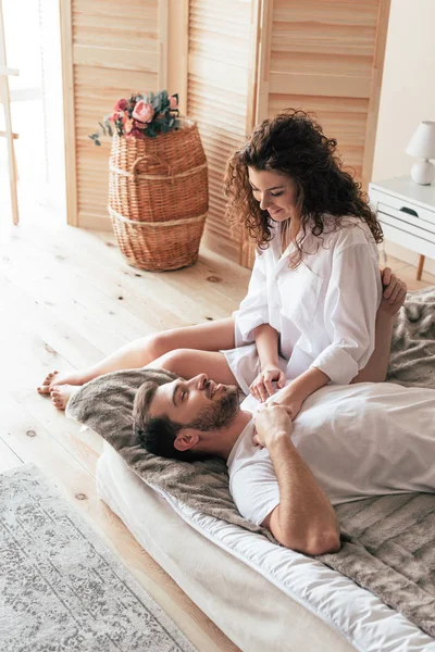 Feliz pareja sonriente en la cama por la mañana en el dormitorio - foto de stock