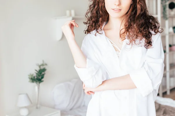 Vista parziale di giovane donna in camicia bianca in camera da letto — Foto stock