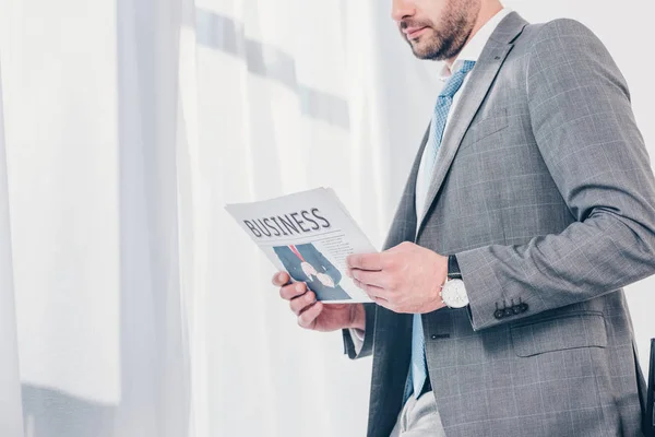 Cropped view of businessman in suit holding newspaper in office with copy space — Stock Photo