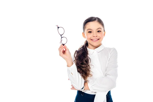 Adorable écolière souriante en tenue formelle tenant des lunettes et posant isolé sur blanc avec espace de copie — Photo de stock