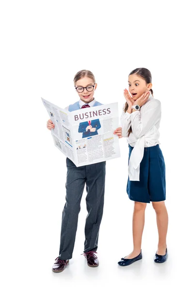 Школьницы в формальной одежде читают деловую газету On White — стоковое фото