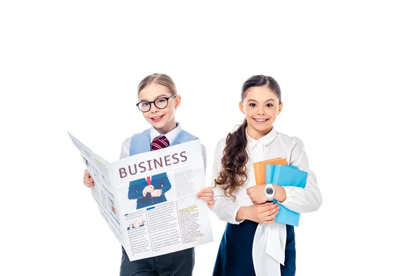 Lächelnde Schulmädchen in offizieller Kleidung mit Wirtschaftszeitung und Büchern auf weißem Hintergrund — Stockfoto
