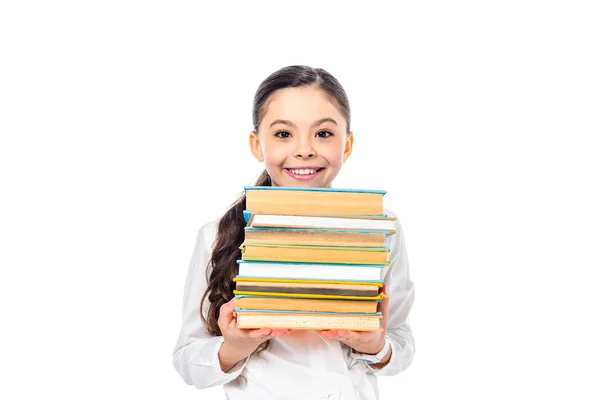 Lächelndes Schulmädchen, das Bücher in die Kamera hält und isoliert auf weiß schaut — Stockfoto