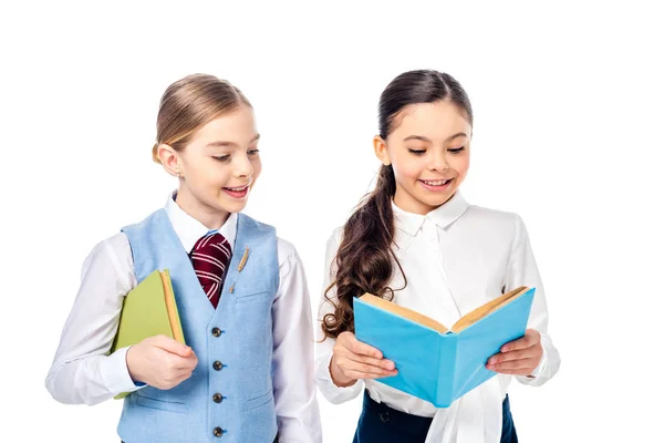 Sorridente alunas no formal desgaste leitura livro isolado no branco — Fotografia de Stock