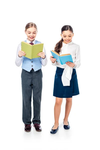 Lächelnde Schulmädchen in offizieller Kleidung lesen Bücher auf Weiß — Stockfoto