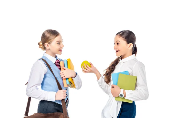 Schulmädchen in offizieller Kleidung mit Büchern und Apfel reden isoliert auf Weiß — Stockfoto