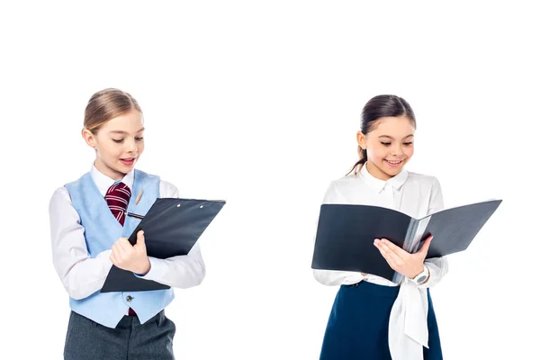 Улыбающиеся школьницы в формальной одежде держат папки 