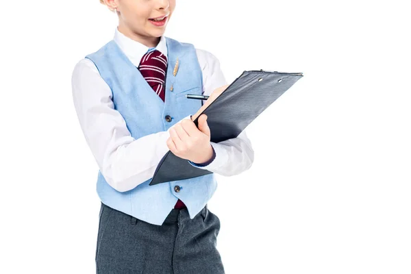 Recortado vista de colegiala en formal desgaste escritura en portapapeles aislado en blanco - foto de stock