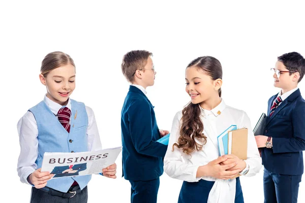 Lächelnde Schulmädchen mit Büchern und Zeitungen, die so tun, als wären sie Geschäftsleute auf weißem Grund — Stockfoto