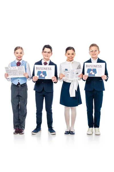 Smiling schoolchildren pretending to be businesspeople with newspapers looking at camera On White — Stock Photo