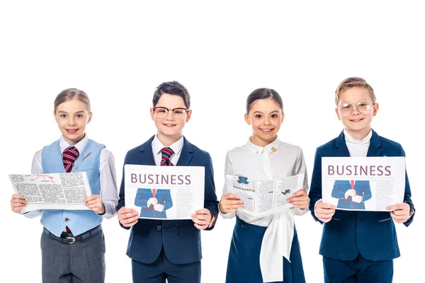 Lächelnde Schulkinder, die sich als Geschäftsleute ausgeben, mit Zeitungen, die isoliert auf weiß in die Kamera schauen — Stockfoto