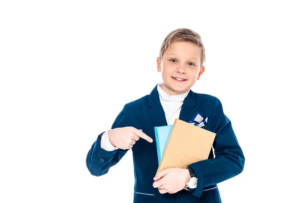 Happy schoolboy in formal wear pointing with finger at books Isolated On White — Stock Photo