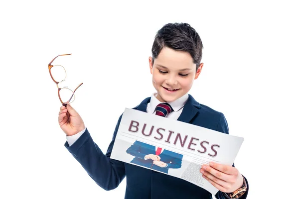 Schuljunge in offizieller Kleidung mit Brille, die Wirtschaftszeitung auf weißem Hintergrund liest — Stockfoto