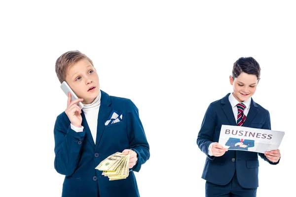 Школьник с деньгами разговаривает по смартфону в то время как другой мальчик читает газету притворяясь бизнесменом в изоляции от Уайта — стоковое фото