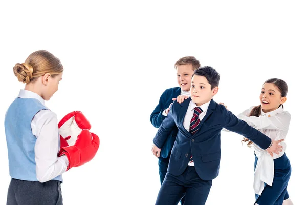Écolière en gants de boxe avec des écoliers intimidant écolier isolé sur blanc — Photo de stock