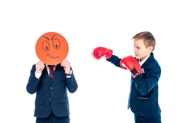 Schüler hält wütenden Gesichtsausdruck Karte, während andere Schüler boxen in Boxhandschuhen isoliert auf weiß — Stockfoto