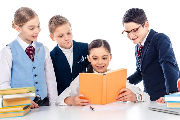 Школярі прикидаючись бізнесмени на столі з школярка читання книг, ізольованих на білому — стокове фото