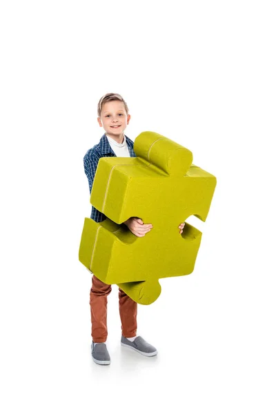 Glücklicher Junge mit Puzzleteil, der in die Kamera auf weiß schaut — Stockfoto