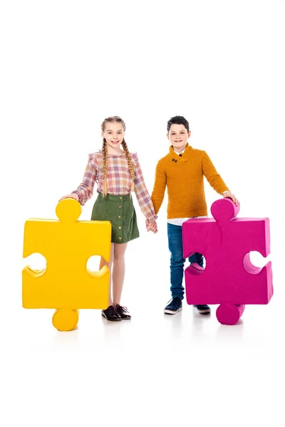 Happy kids with jigsaw puzzle pieces holding hands on white — Stock Photo