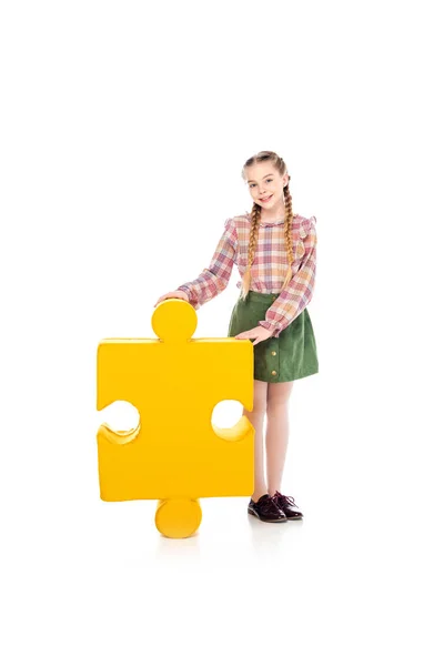 Smiling kid with jigsaw puzzle piece looking at camera on white — Stock Photo