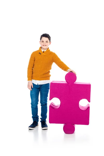 Felice ragazzo in posa con puzzle pezzo su bianco — Foto stock
