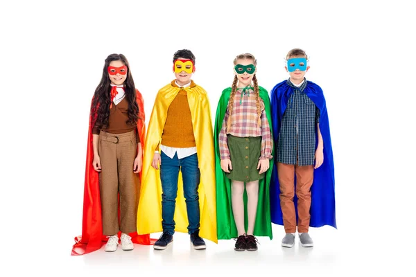 Enfants heureux en costumes de super-héros et masques regardant la caméra sur blanc — Photo de stock