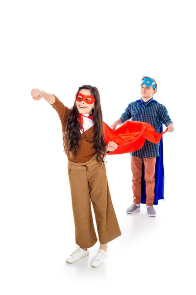 Хлопчик тримає накидку дитини в костюмі супергероя позує з простягнутою рукою На білому — стокове фото