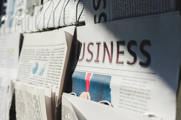 Selective focus of different print newspapers on stand in sunlight — Stock Photo