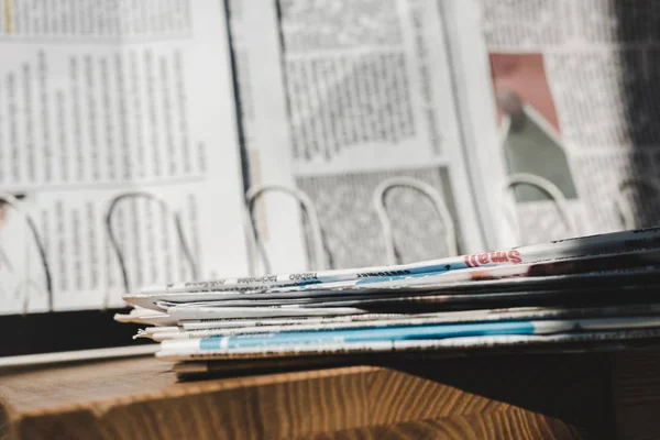 Selective focus of different print newspapers in pile near stand — Stock Photo