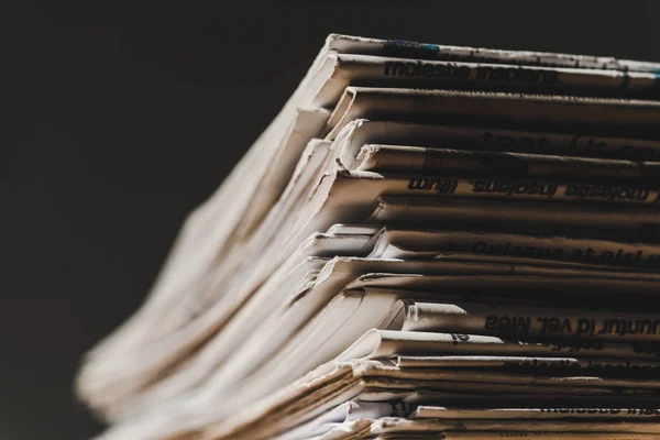 Verschiedene gedruckte Zeitungen in Stapel isoliert auf schwarz — Stockfoto