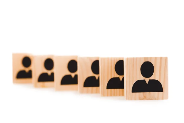 Enfoque selectivo de bloques de madera con iconos humanos negros en fila aislados en blanco - foto de stock