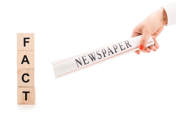 Vista cortada da mulher segurando jornal perto de blocos de madeira com letras de fato isolado no branco — Fotografia de Stock