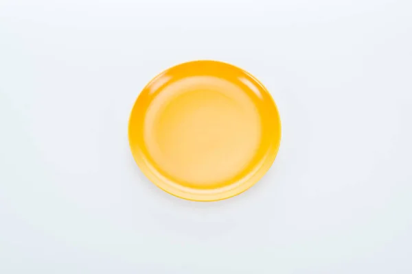 Vue de dessus de la plaque jaune vide brillant sur fond blanc — Photo de stock