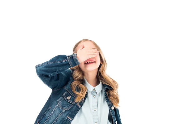Enfant souriant en jean couvrant les yeux avec la main isolé sur blanc — Photo de stock