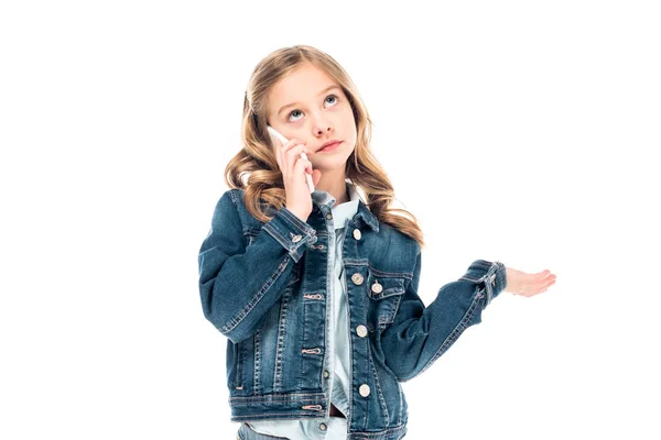 Niño en chaqueta de mezclilla hablando en el teléfono inteligente y mirando hacia arriba aislado en blanco - foto de stock