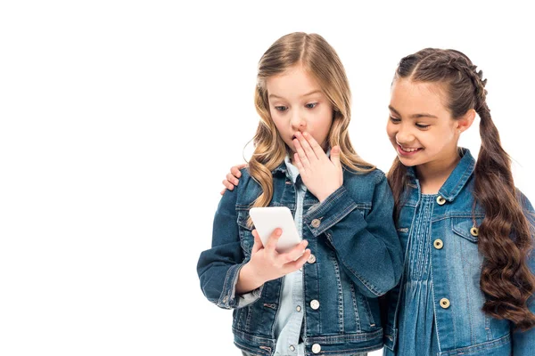 Niño sorprendido usando teléfono inteligente con amigo aislado en blanco - foto de stock