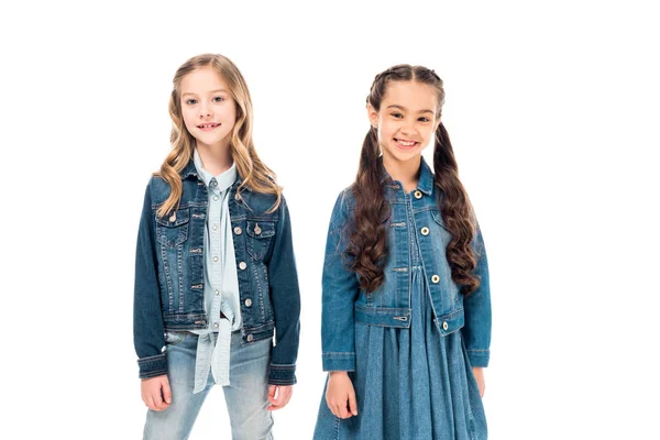 Zwei Kinder in Jeanskleidung blicken mit einem Lächeln isoliert auf weiß in die Kamera — Stockfoto